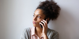 worried looking woman holding a cell phone