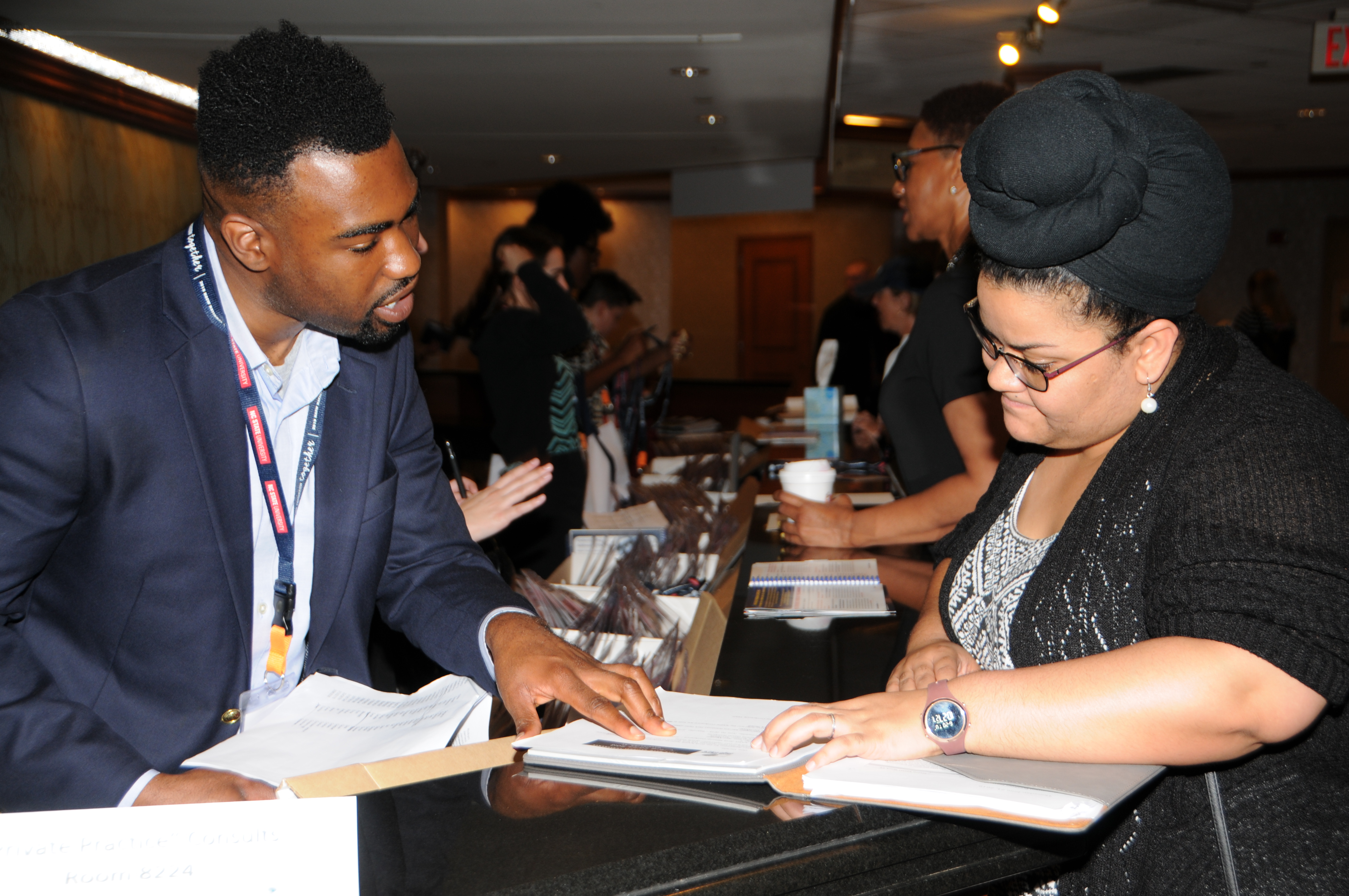 three diverse women conference attendees stand clapping