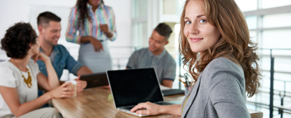 professional woman works at a table with colleagues