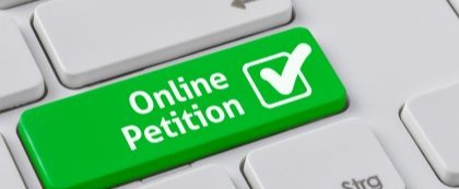 keyboard with green key labeled online petition with a check mark