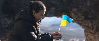 sitting woman holds Ukranian flag