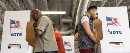 people standing at voting booths