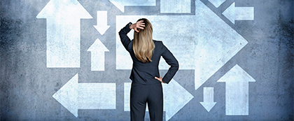 woman in suit looks at arrows pointing in multiple directions