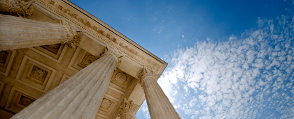 white building with columns, blue sky above it
