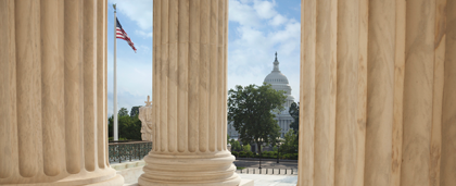 flagpole and Congress dome seen through marble pillars