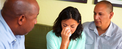 woman upset, two people console her