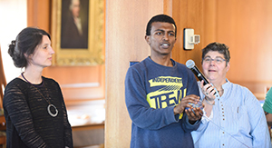 three people, one speaking into a microphone