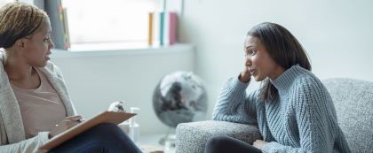 Two women talking on a couch