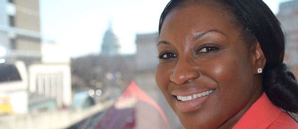 woman smiling and looking at camera with capitol in the background