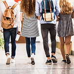 four young people walking down hallway