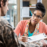 woman with clipboard helps man in fatigues