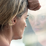sad woman looks through window