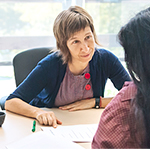 woman sitting at desk speaking with a client