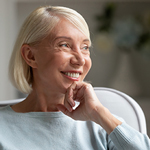 smiling woman sits in comfortable chair