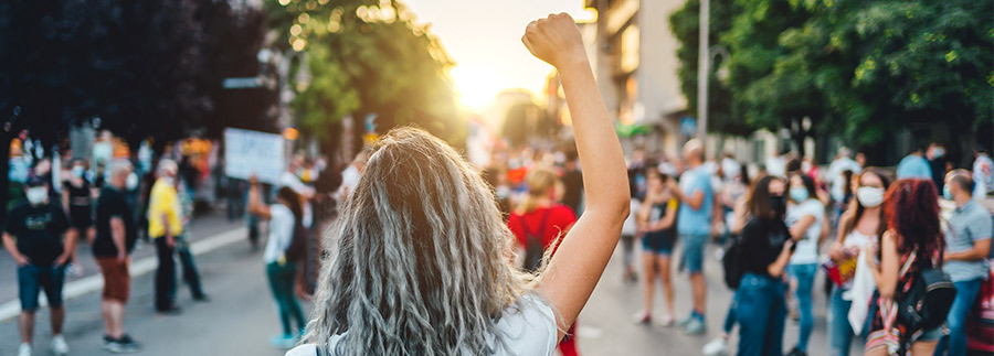 person with raised fist in a crowded street