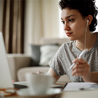 woman studying with laptop and earbuds