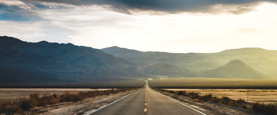 empty road with mountain in the background