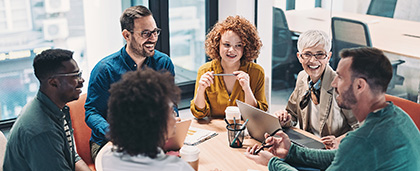 adults conversing around a table in an office setting