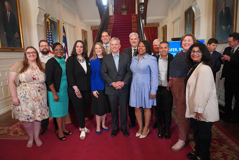 North Carolina Gov. Josh Stein poses with NASW North Carolina Chapter members after signing the compact into law in June 2025