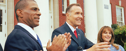 three people at a podium outdoors