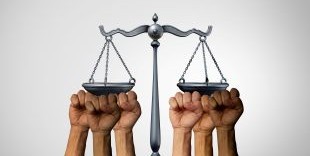 fists underneath the scales of justice