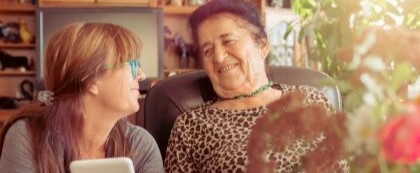 elderly woman sitting with younger woman
