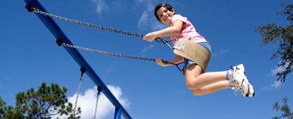 child swinging high in a swing