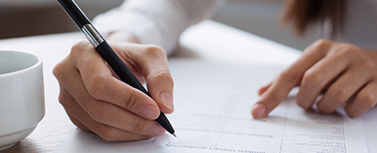 woman's hands filling out a paper application