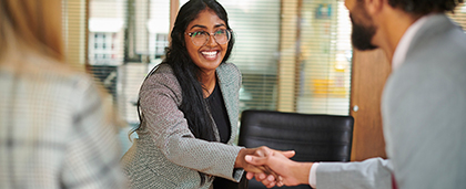 smiling woman shakes hands at a job interview