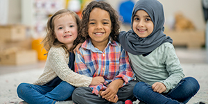 children of diverse backgrounds sit together