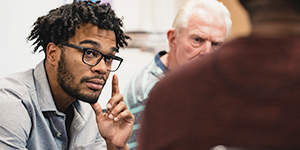 man listening to another speak