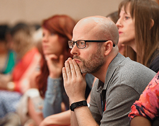 man in audience listens intently