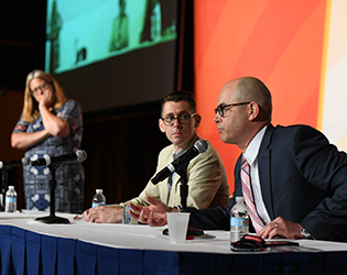 three panelists on stage