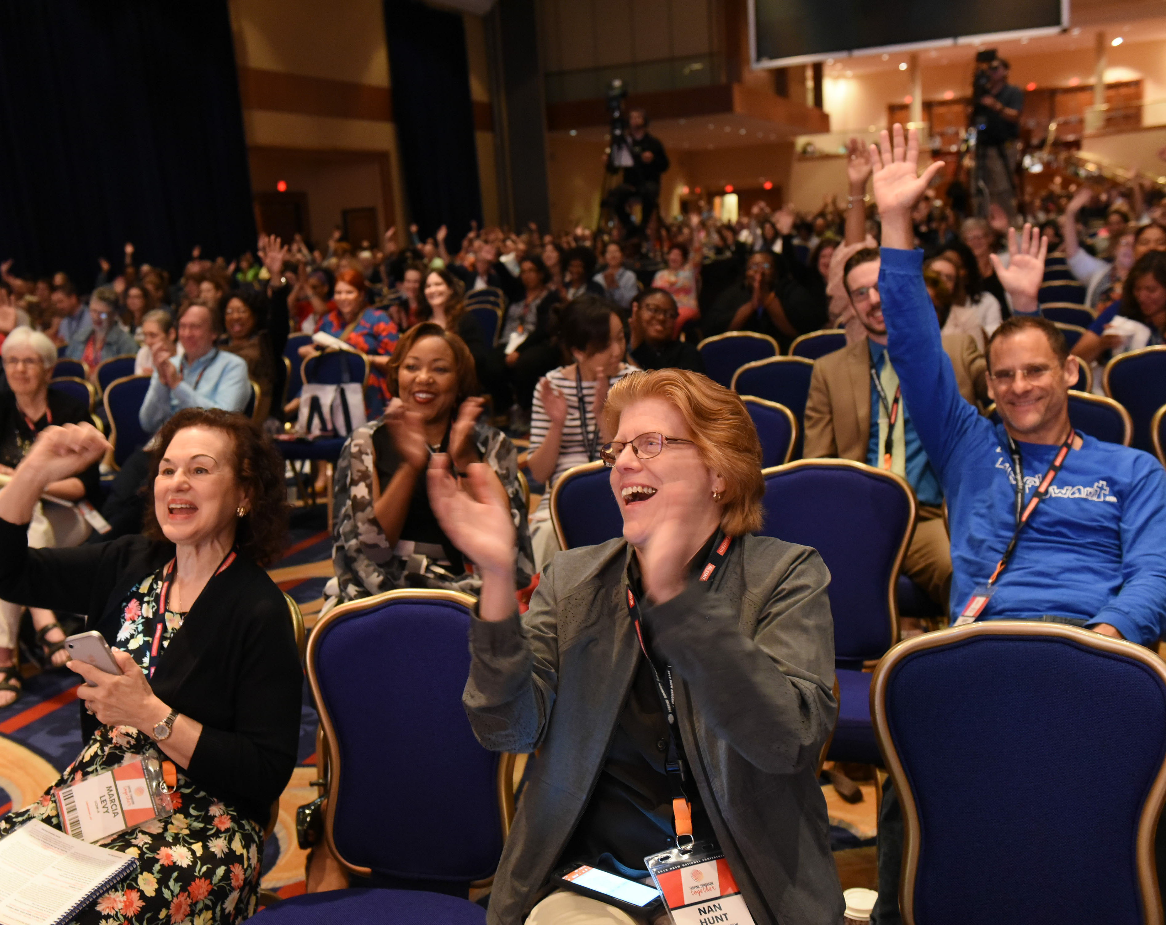 seated crowd of attendees cheering