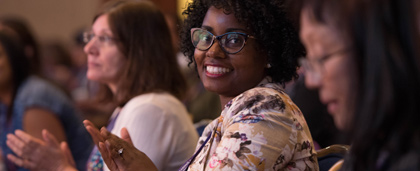 smiling woman in audience looks towards camera