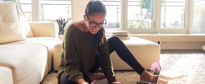 woman sitting on floor with laptop in front of her