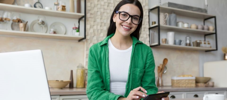 woman smiling at camera while holding calculator