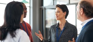 woman speaking to a group of colleagues