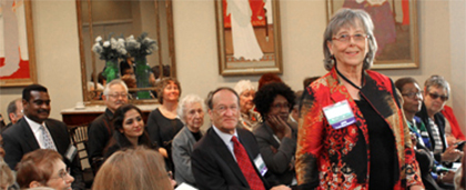 woman stands in the audience at an event