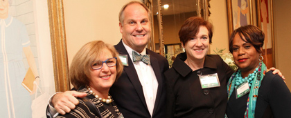 four smiling people at an event