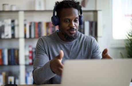 man sitting in front of laptop with headphones on