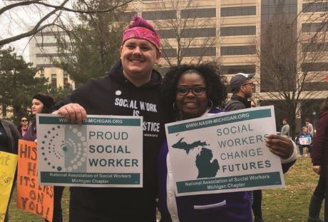 two people standing and smiling at a protest