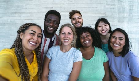 students smiling in group outside building