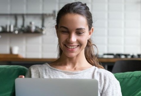young woman smiling while on laptop