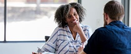 woman speaking with a man while holding clipboard