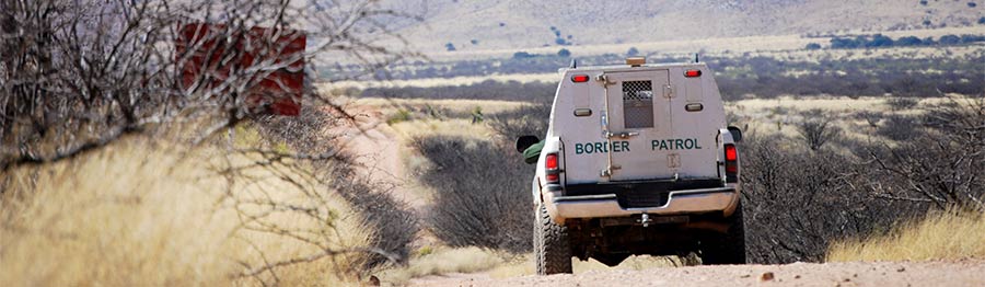 border patrol truck drives on dirt road