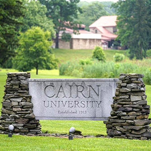 stones and sign that reads Cairn University - established 1913 style=