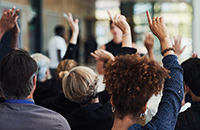 audience at conference with hands raised