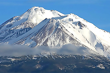 snow-covered mountain with wispy clouds