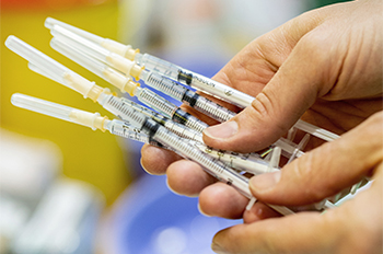 hand holds several syringes